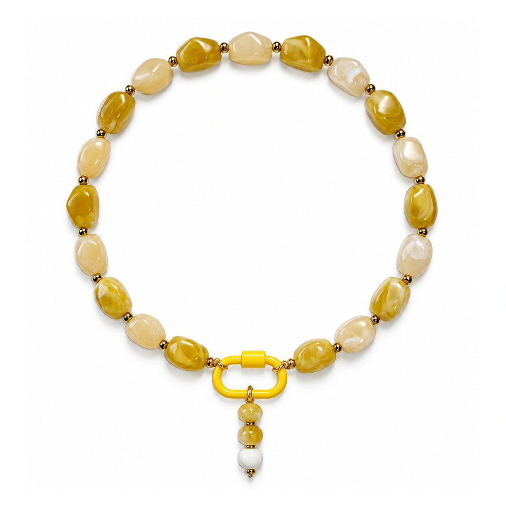 Yellow and cream acrylic beaded necklace with a yellow and white beaded drop pendant on a white background.