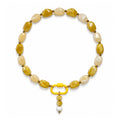 Yellow and cream acrylic beaded necklace with a yellow and white beaded drop pendant on a white background.