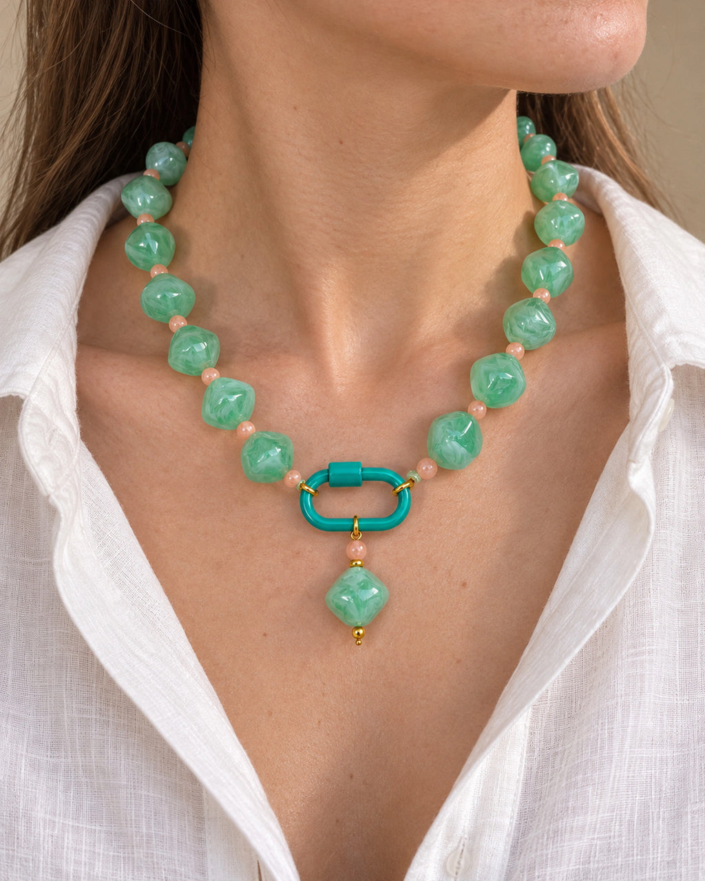 Mint green with peach accents acrylic beaded necklace with a mint-green rounded diamond pendant, shown in a close-up styling view.