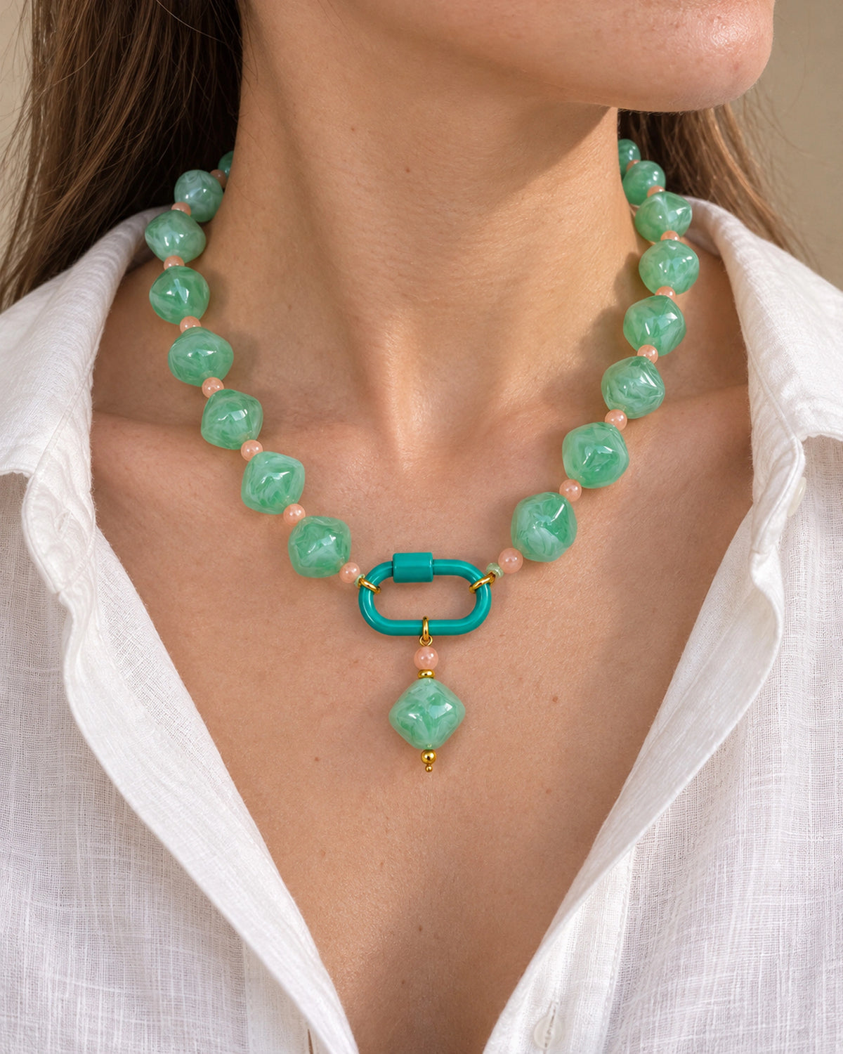 Mint green with peach accents acrylic beaded necklace with a mint-green rounded diamond pendant, shown in a close-up styling view.