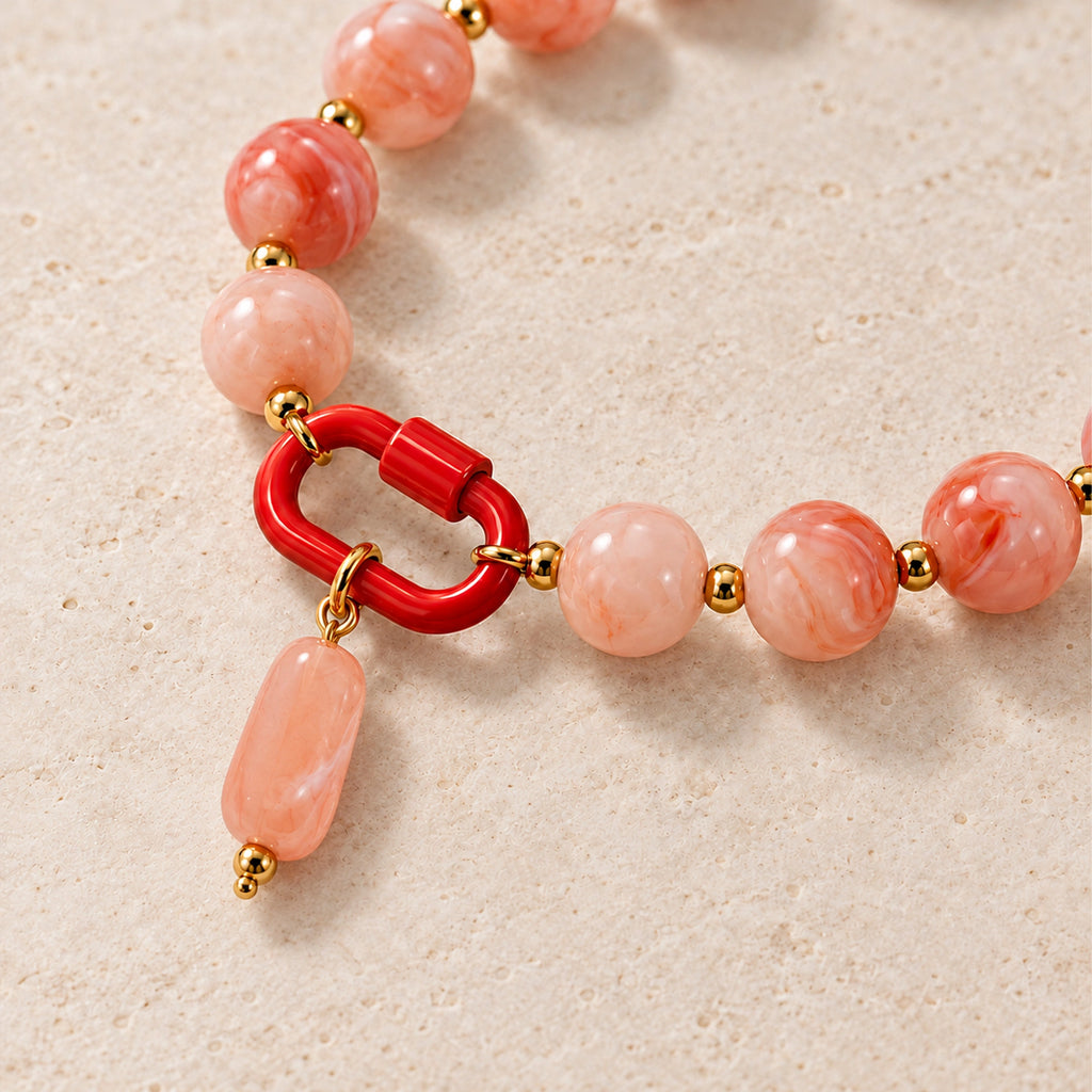 Close-up of the pink oval pendant, front clasp and acrylic beads.
