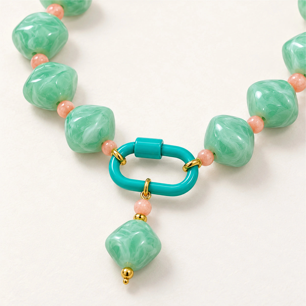 Close-up of the mint-green rounded diamond pendant, front clasp and acrylic beads.