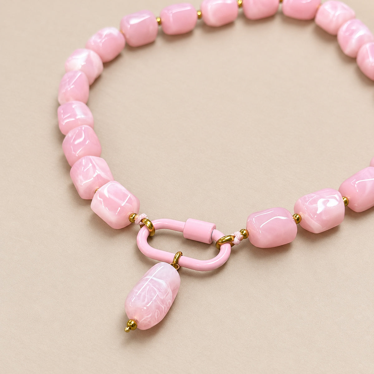 Close-up of the pink oval pendant, front clasp and acrylic beads.