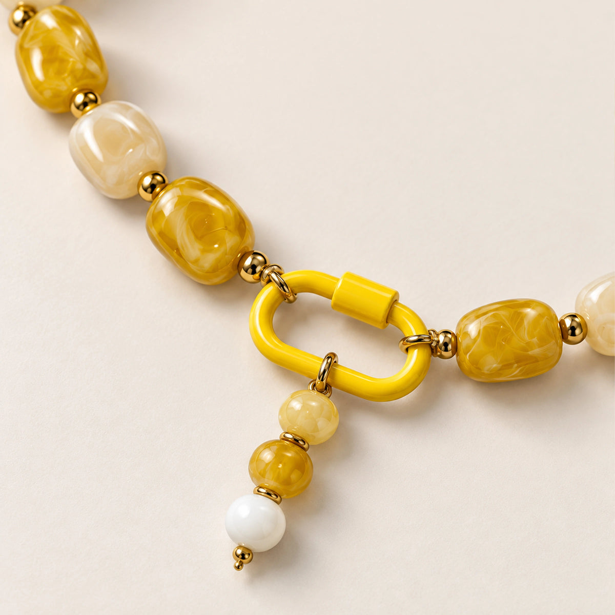 Close-up of the yellow and white beaded drop pendant, front clasp and acrylic beads.