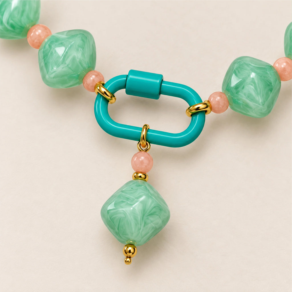 Close-up of the mint-green rounded diamond pendant, front clasp and acrylic beads.